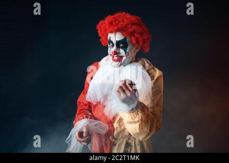 Portrait de scary clown sanglant avec un défaut. Avec l'homme en costume maquillage carnaval, mad maniac Banque D'Images