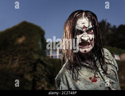 Une fille zombie effrayante près de la maison abandonnée. Horreur. Halloween Banque D'Images