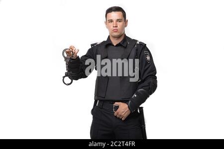 Soldat des forces spéciales en uniforme noir et l'armure de corps détient des menottes, fond blanc. Agent de police armés, l'application de la Garde côtière canadienne Banque D'Images