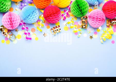 Fond de fête d'anniversaire sur violet. Vue de dessus. Bordure en serpentin coloré, boules et confettis. Banque D'Images