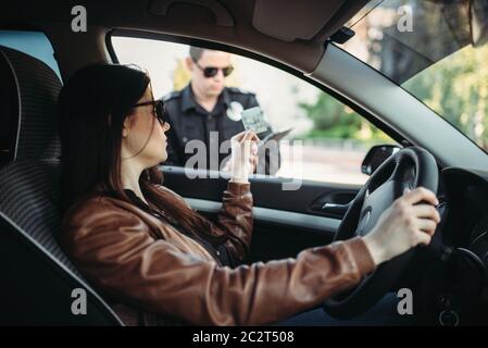 La cdp mâle en uniforme écrit une amende à la pilote. La protection de la loi, le trafic automobile, de l'inspecteur du travail de contrôle de la sécurité Banque D'Images