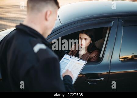 Policier en uniforme écrit une amende à la pilote. La protection de la loi, le trafic automobile, de l'inspecteur du travail de contrôle de la sécurité Banque D'Images