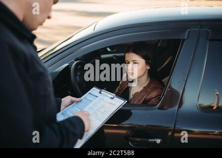 Policier en uniforme écrit une amende à la pilote. La protection de la loi, le trafic automobile, de l'inspecteur du travail de contrôle de la sécurité Banque D'Images