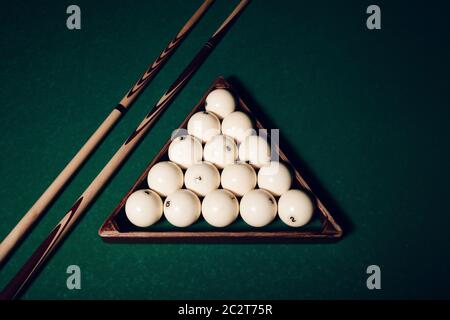 Boules de billard en triangle de bois et bâtons de piscine vue rapprochée Banque D'Images