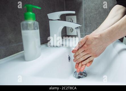 l'homme lave soigneusement ses mains sous le robinet. Banque D'Images