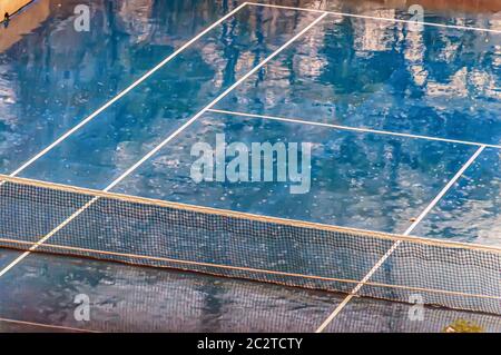 Un court de tennis humide d'un orage de l'après-midi. Banque D'Images