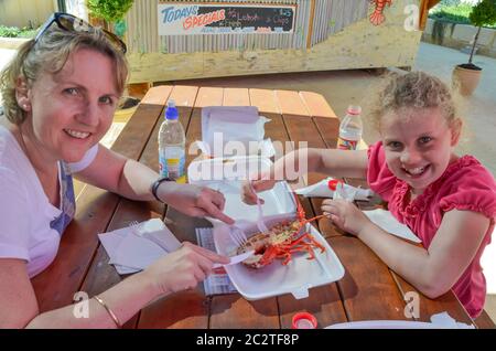 Une mère et une jeune fille australiennes partagent un homard cuit au Lobster Shack dans la ville côtière de Cervantes, en Australie occidentale Banque D'Images