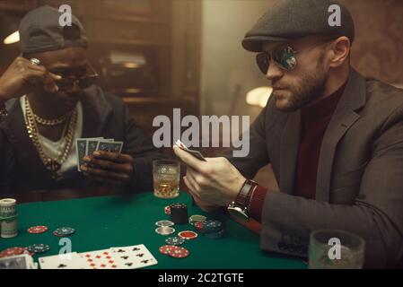 Joueur de poker professionnel ressent le risque, casino. Jeux de la dépendance de chance. Homme avec des cartes dans les mains loisirs dans la maison de jeu Banque D'Images