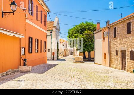 Croatie, place pavée et rue avec un ancien puits dans la ville historique de Nin en Dalmatie Banque D'Images