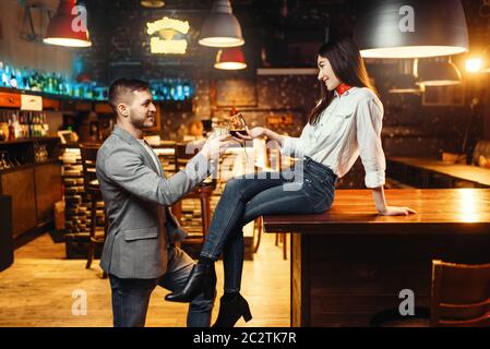 Femme de flirter avec l'homme, de l'amour couple at bar comptoir. Loisirs Les amateurs de pub, mari et femme se détendre ensemble dans une discothèque Banque D'Images