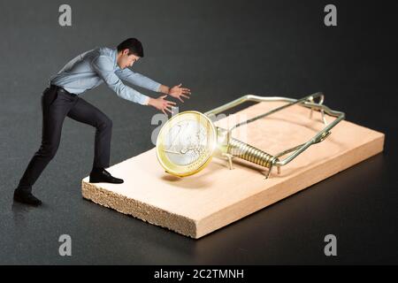 Homme d'affaires essayant de choisir une pièce d'or dans le mousetrap Banque D'Images
