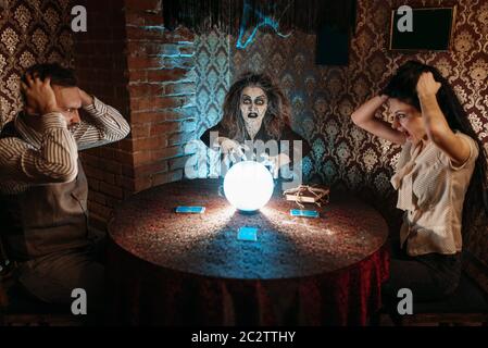 Lit sorcière magie effrayant sort sur une boule de cristal, des jeunes dans l'horreur sur seance spirituelle. Appels foreteller femelle les esprits Banque D'Images