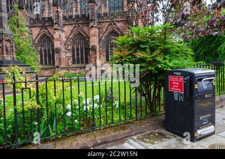 Chester, Royaume-Uni : 14 juin 2020 : un bac à litière à l'extérieur de la cathédrale de Chester affiche une affiche rouge rappelant aux piétons de garder leur distance en raison du Covid- Banque D'Images