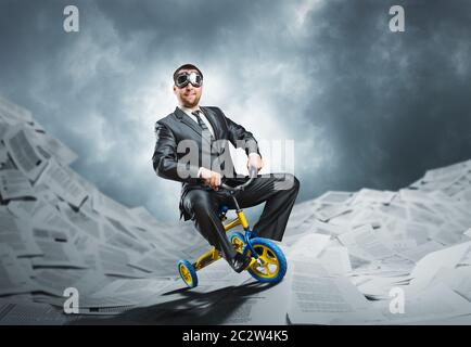 Étrange businessman riding un petit vélo contre papier fond