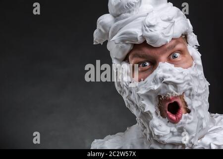L'homme surpris avec de la mousse à raser sur son visage Banque D'Images