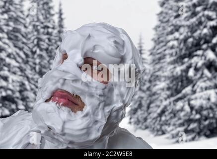 Surpris homme étrange avec de la mousse à raser sur son visage et sur sa tête au-dessus de la forêt en hiver Banque D'Images