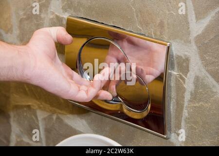 En appuyant sur le bouton de rinçage sur le mur Banque D'Images