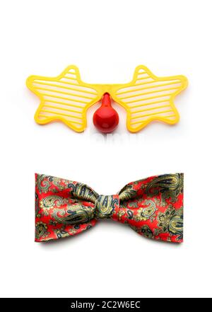 Partie lunettes et noeud papillon clown faisant face sur fond blanc Banque D'Images