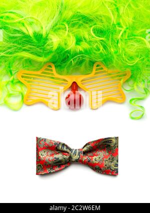 Parti perruque, lunettes et noeud papillon clown faisant face sur fond blanc Banque D'Images