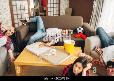 Les fans de football, dormir à la maison, gueule de matin. Amis ivres après la célébration de la victoire de son équipe favorite, party avec bière, pizza et pop-corn Banque D'Images