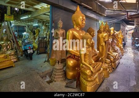 Des statues de Bouddha se trouvent devant une usine de statues de Bouddha et d'autres objets religieux dans une voie latérale au large de Bamrung Muang Road, Bangkok, Thaïlande Banque D'Images