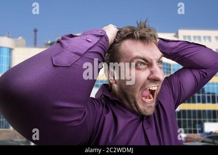 Mad man crier contre le bureau Banque D'Images