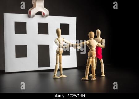 Famille de figurines en bois heureux près de maison en papier Banque D'Images