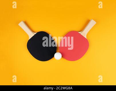 directement au-dessus de la photo de deux raquettes de tennis de table et de balle sur fond orange. Banque D'Images