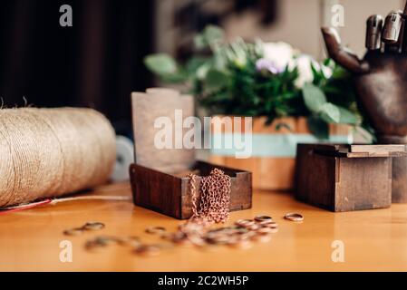 Accessoires pour les travaux d'aiguille, peu d'anneaux en métal et en bois décoratif fort sur la table, gros plan. Des bijoux, bijouterie faisant Banque D'Images