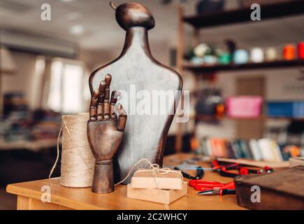 Accessoires de couture, mannequin et main en bois sur la table, gros plan. Des bijoux, de l'intérieur de l'atelier Banque D'Images