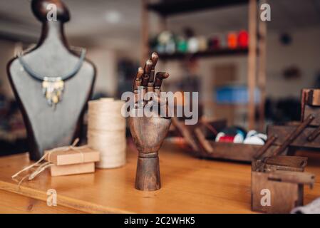 Accessoires pour les travaux d'aiguille, main en bois et mannequin avec la société fait à la main sur la table dans l'atelier, libre. Des bijoux Banque D'Images