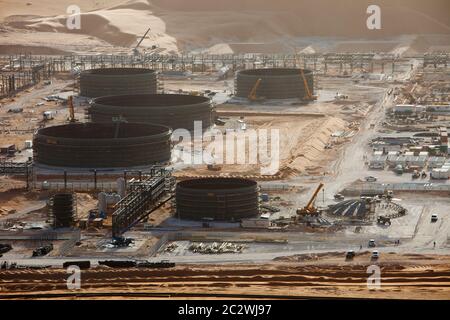 Des cadres pour les conduites et les grands réservoirs de stockage de pétrole sont en construction dans une nouvelle installation pétrolière dans le désert du Sahara. Banque D'Images