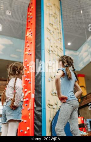 Deux petites filles regarde sur mur d'escalade, les enfants game center. Childs excités s'amuser sur l'aire de l'intérieur. Les enfants jouant dans une salle de jeux Banque D'Images