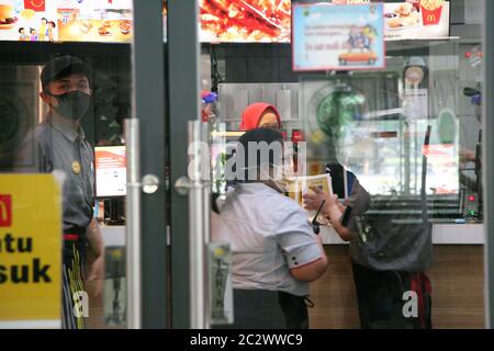 Les employés de MC Donalds portent un masque et un masque facial au rez-de-chaussée, spécialement pour les magasins d'alimentation Gambir Station, Jakarta. Pour protéger la sécurité des consommateurs et des employés, McDonald's (McD) augmente les précautions pour s'assurer que ses points de vente sont propres et sûrs, à une nouvelle période d'application normale, dans le contexte du nombre toujours croissant de cas positifs de COVID-19. Mesures prises, comme la vérification de la température corporelle de tous les employés et fournisseurs de McD, chaque jour avant le travail. Il applique également une politique de la porte unique dans les restaurants et vérifie la température corporelle de tous les consommateurs qui entreront dans le restaurant Banque D'Images