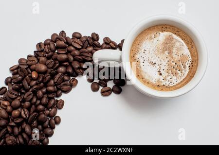 Une tasse de café fort. Faire revenir les grains de café sur une table blanche. Banque D'Images