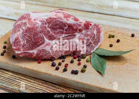 Viande crue aux épices dans une planche de bois. Banque D'Images