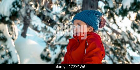 Portrait d'une jolie petite fille qui s'amuse à l'extérieur, un enfant joyeux qui profite d'une journée d'hiver ensoleillée, de joyeuses vacances d'hiver, d'une image panoramique Banque D'Images