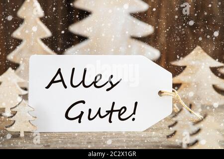 Étiquette avec texte allemand Alles Gute signifie meilleurs voeux. Arbre de Noël en bois blanc comme décoration. Fond en bois brun avec de la neige Banque D'Images