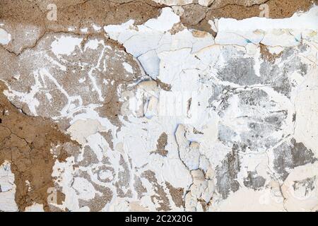 Plâtre fissuré et effritant d'un mur blanc - un motif de papier peint ou de travail pour une équipe de construction pour réparer un vieux bâtiment. Liquidation d'emerge Banque D'Images