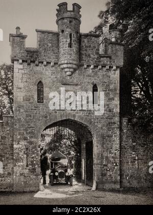 Vue du début des années 1920 sur une voiture classique qui quitte la porte d'entrée Tudor du XVIIIe siècle pour le château de Slane, dans le comté de Meath, en Irlande. Initialement photographié par Clifton Adams (1890-1934) pour 'Ireland: The Rock Wharce I was hewn', un reportage du magazine National Geographic de mars 1927. Banque D'Images