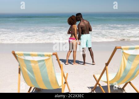 Couple de course mixte embrassant sur la plage Banque D'Images