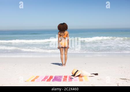 Femme afro-américaine debout sur la plage Banque D'Images