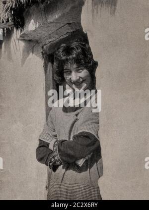 Une photographie du début des années 1920 d'une jeune femme à l'entrée de son chalet dans le comté de Galway sur la côte ouest de l'Irlande. Initialement photographié par Clifton Adams (1890-1934) pour 'Ireland: The Rock Wharce I was hewn', un reportage du magazine National Geographic de mars 1927. Banque D'Images