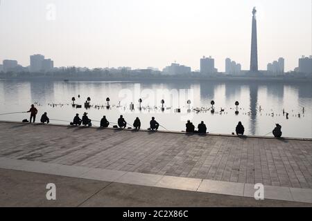 Pyongyang, Corée du Nord - 1er mai 2019 : pêcheurs sur la promenade en face de la Tour de l'idée de Juche au lever du soleil Banque D'Images