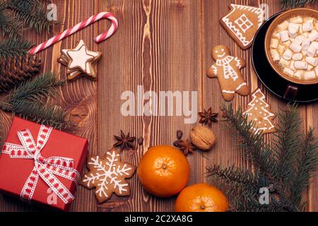 Décoration de Noël avec branches en sapin, mug en verre avec chocolat chaud et guimauve, pain d'épices et boîte cadeau sur fond de bois avec espace pour les copies Banque D'Images