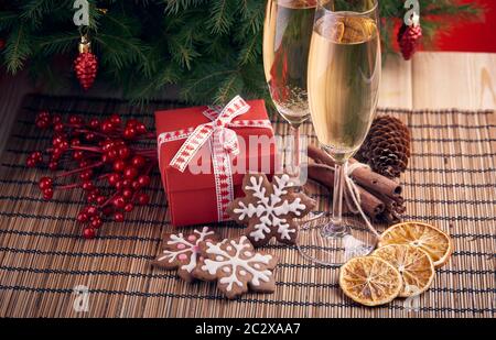 Deux verres avec champange, coffrets cadeaux de Noël et le gingembre cookies debout sur une table près de sapin. Noël et Nouvel an. Banque D'Images