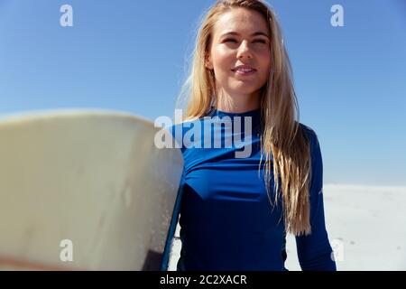 Femme caucasienne pendant la session de surf à la plage Banque D'Images
