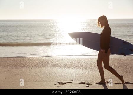 Femme caucasienne pendant la session de surf à la plage Banque D'Images