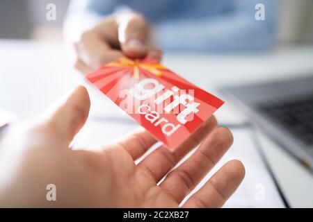 Close-up de l'homme d'affaires mains donnant carte-cadeau pour d'autres affaires Banque D'Images