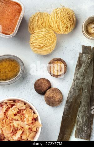 Ingrédients de ramen. Varech de légumes de mer séchés, nouilles soba, pâte miso, flocons de thon, champignons shiitake, sauce miraline, saké dans un c Banque D'Images